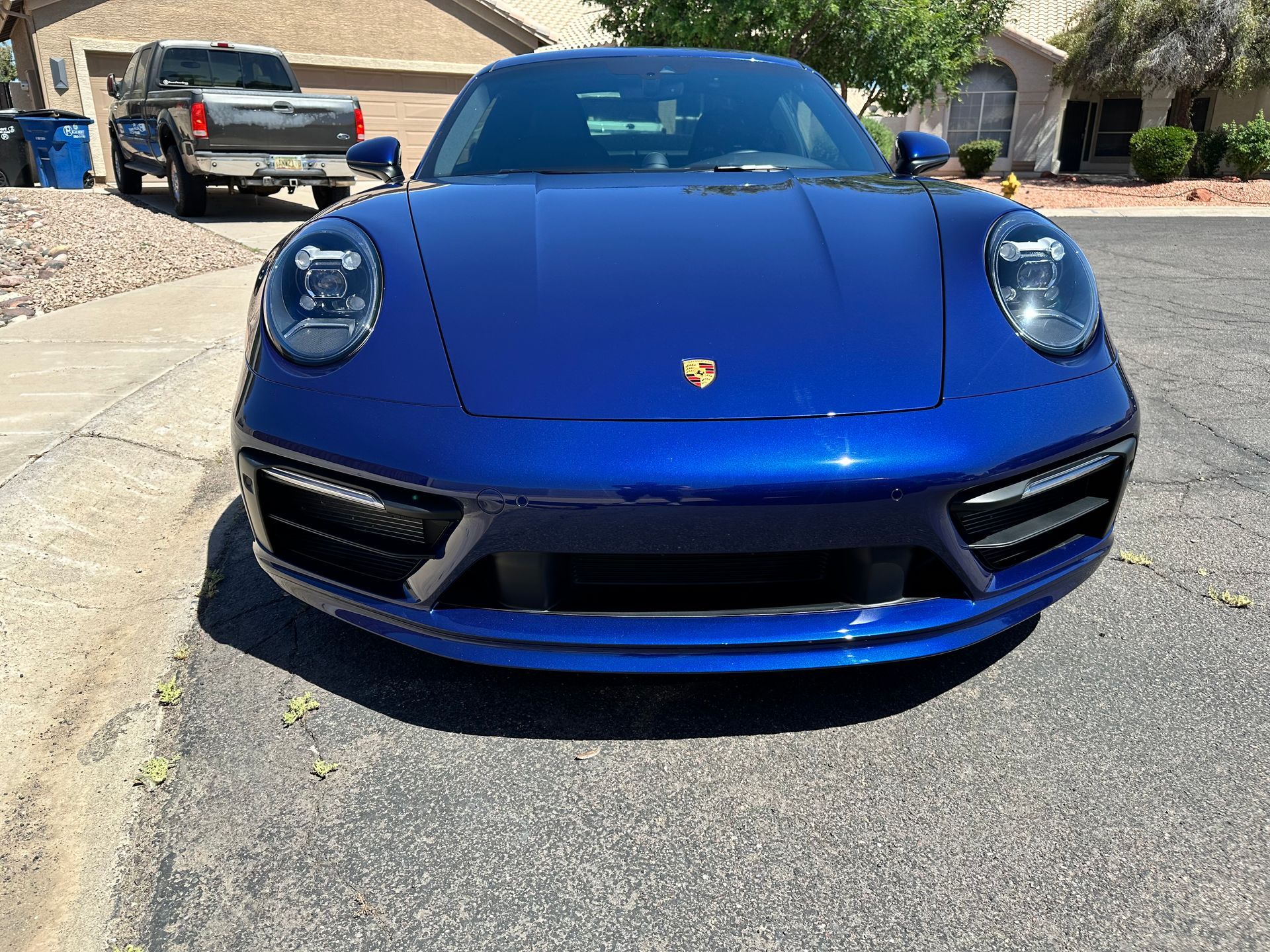 A blue porsche 911 is parked on the side of the road.
