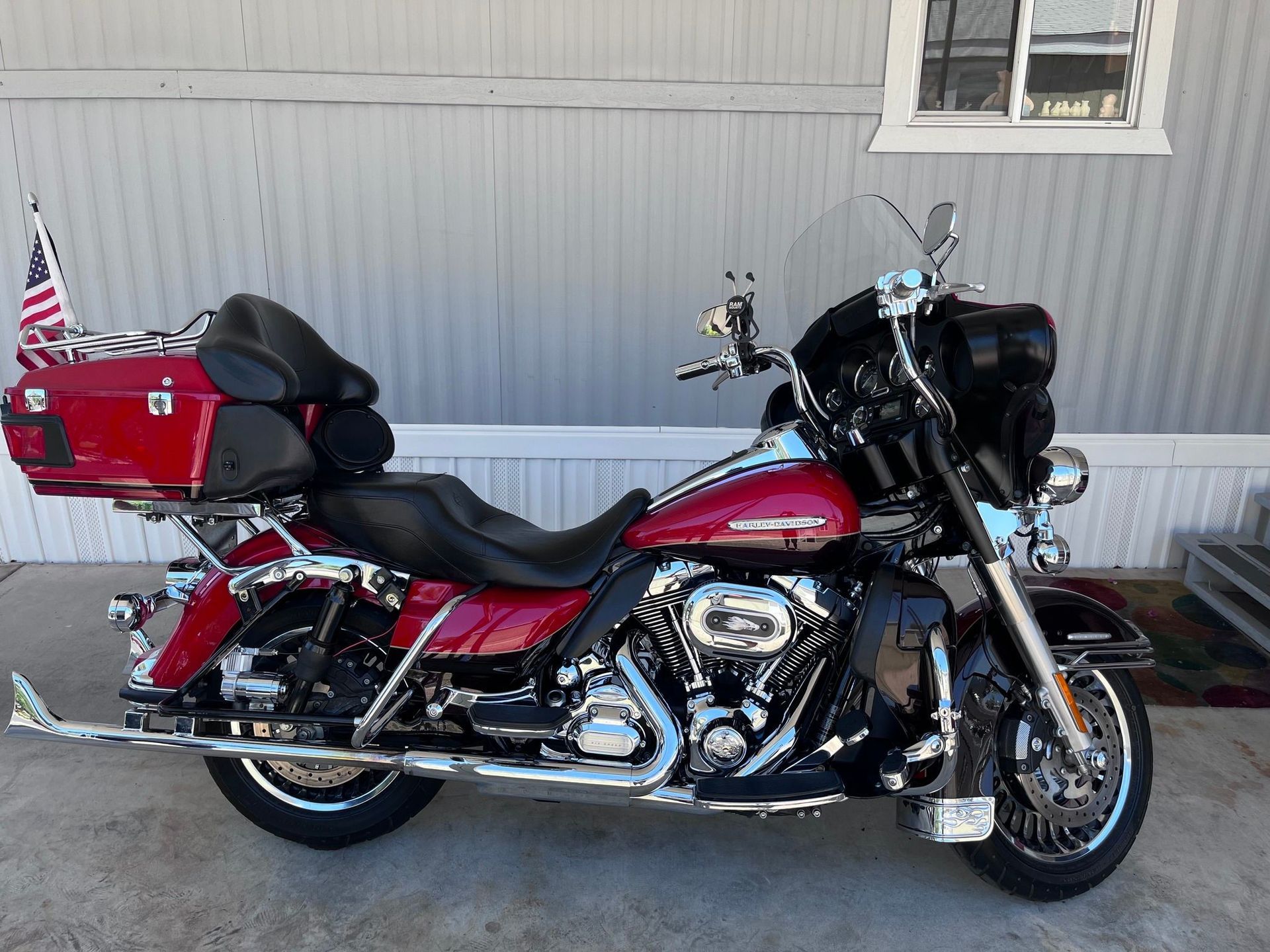 A red harley davidson motorcycle is parked in front of a mobile home.