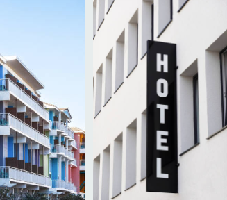 Hotel sign on a white building along a bright street with modern apartments nearby