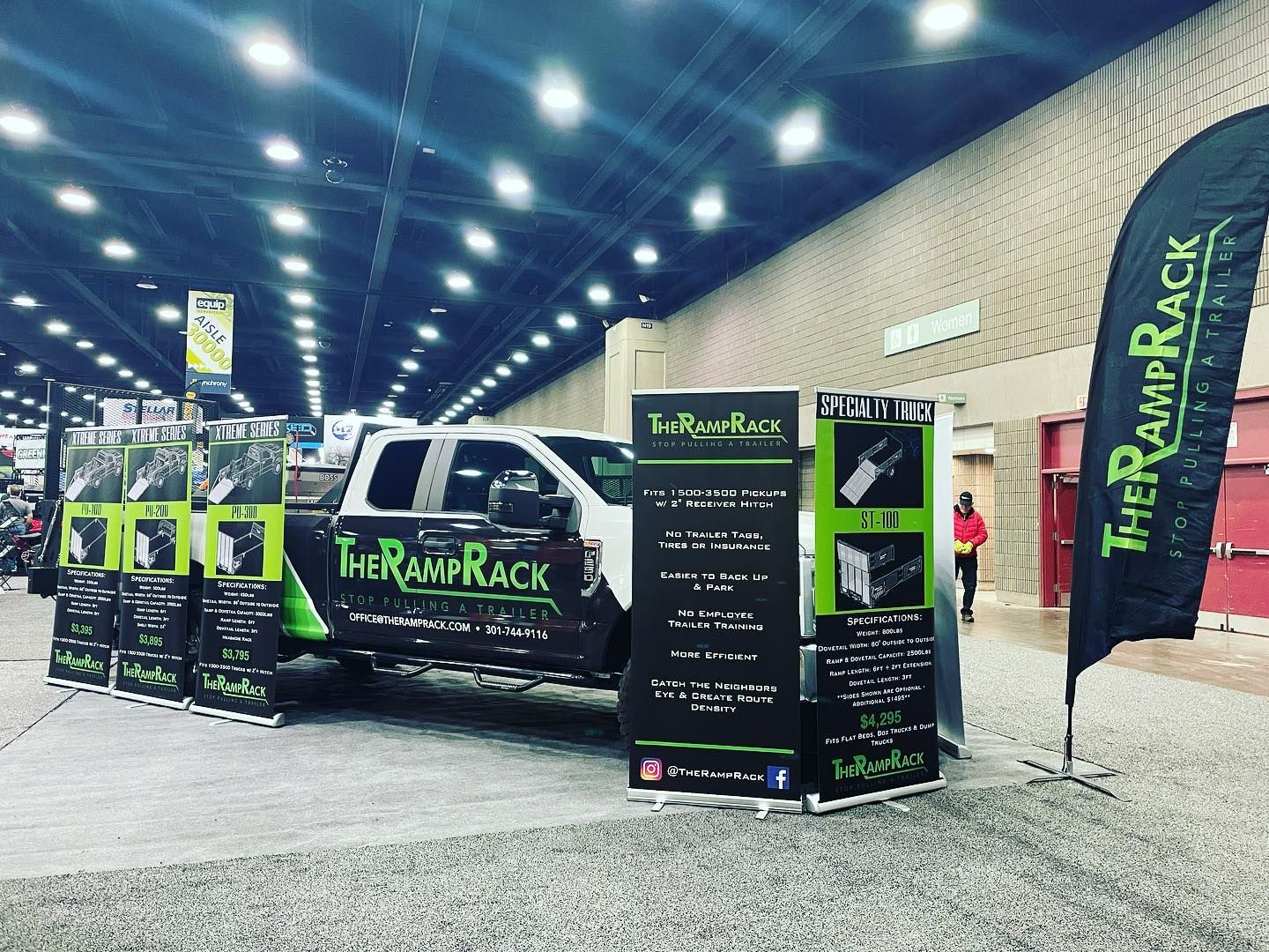 Trade show booth for The Ramp Rack with branded van, banners, and displays in a convention hall