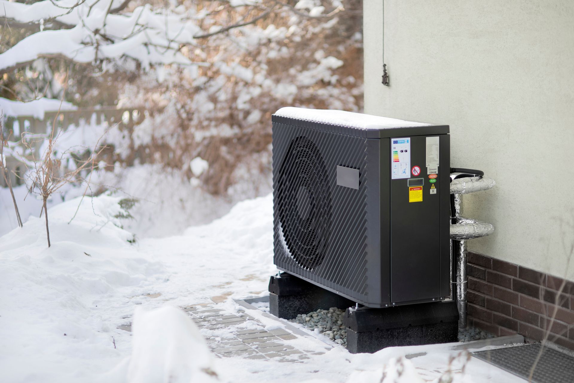 Residential heat pump outdoor unit installed beside home compared to gas furnace in Vancouver.