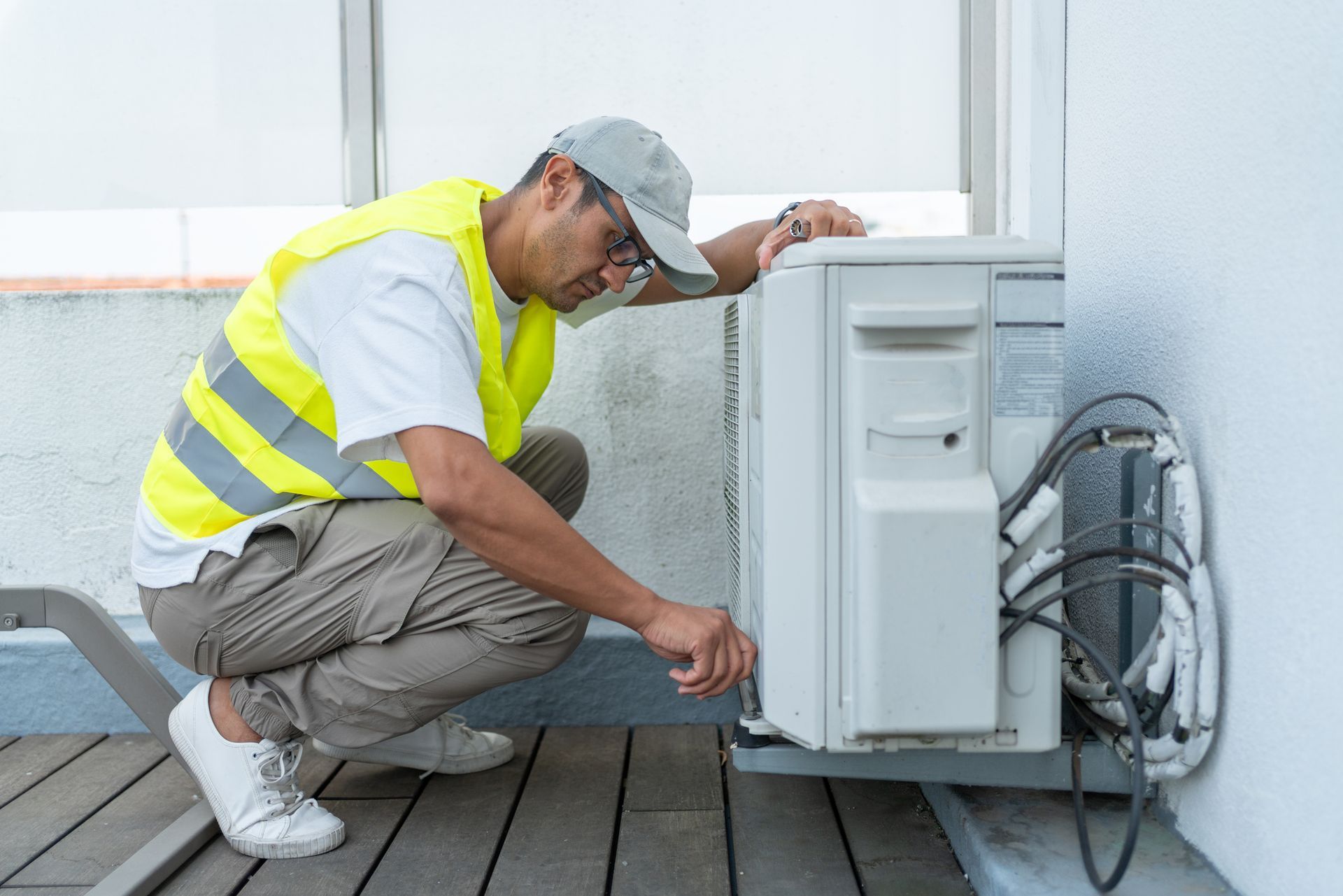 HVAC technician servicing an outdoor heat pump unit during installation in Vancouver BC.