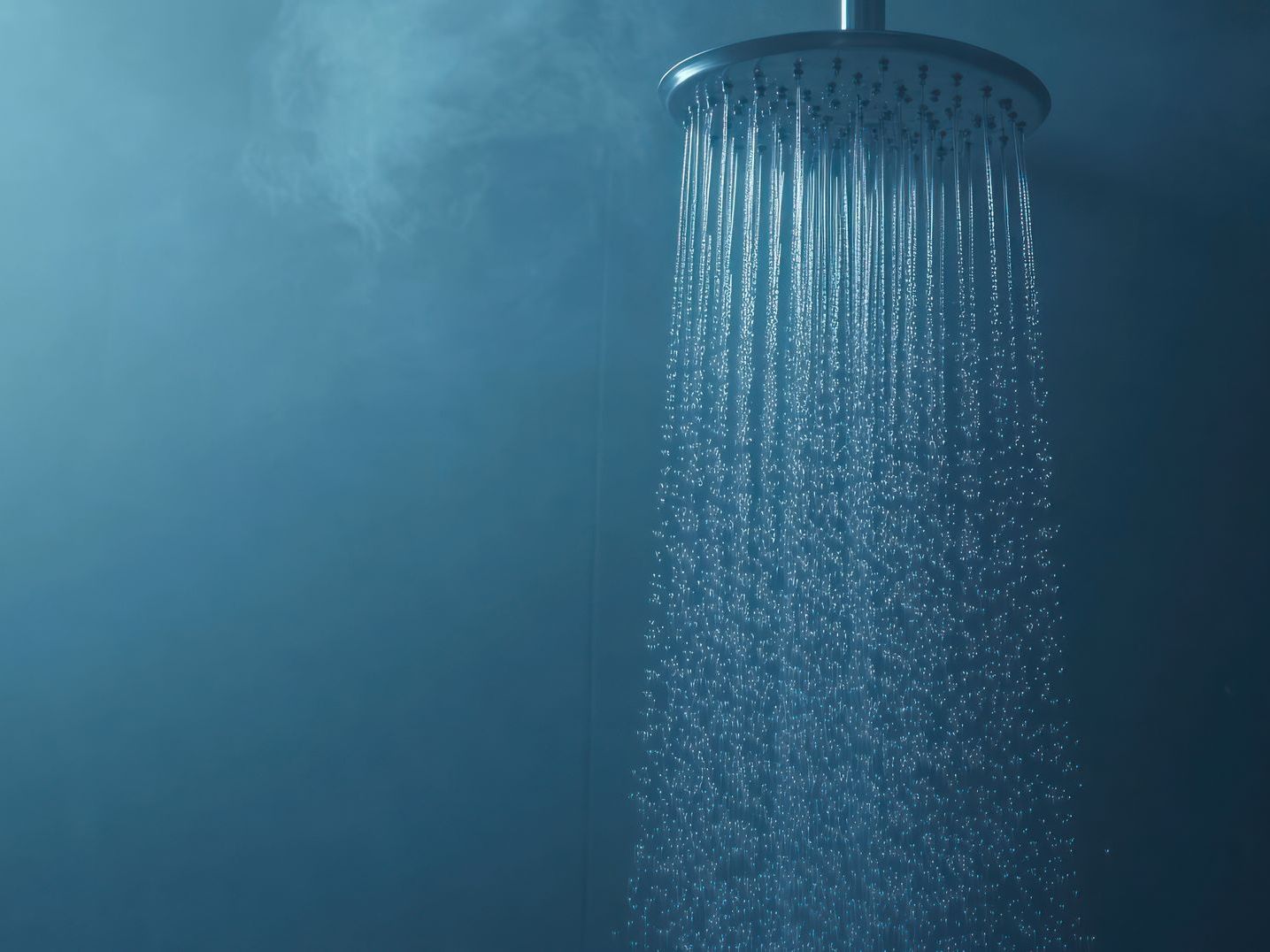 A close up of a shower head with water coming out of it.