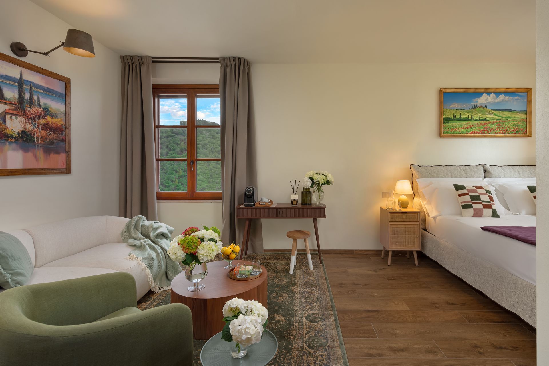 Hotel suite with a couch , chair , table , bed , and view of Tuscany.