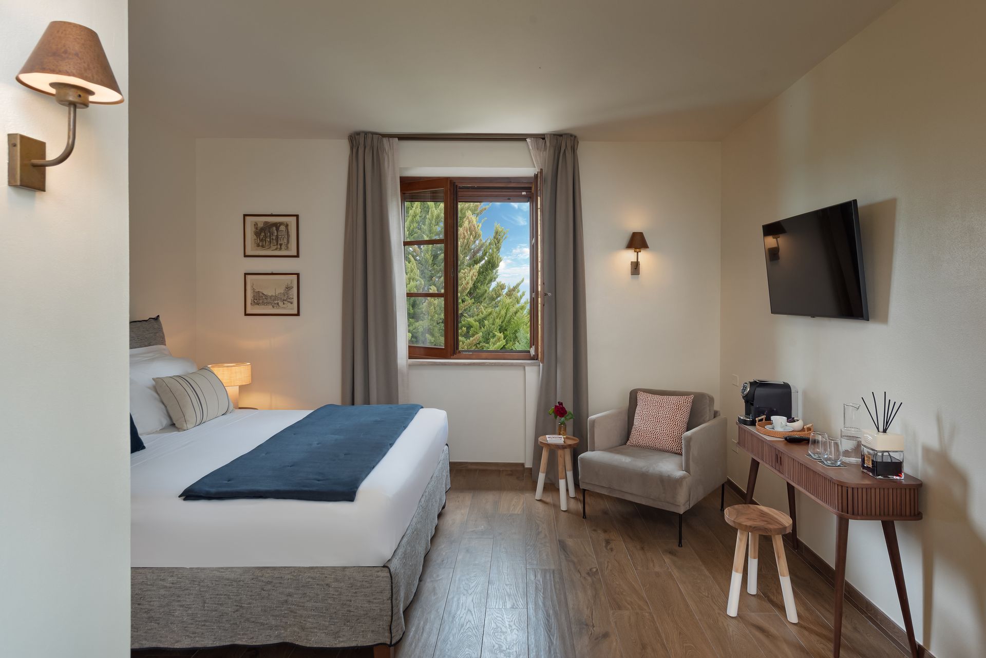 A hotel room with a bed , chair , desk and television.