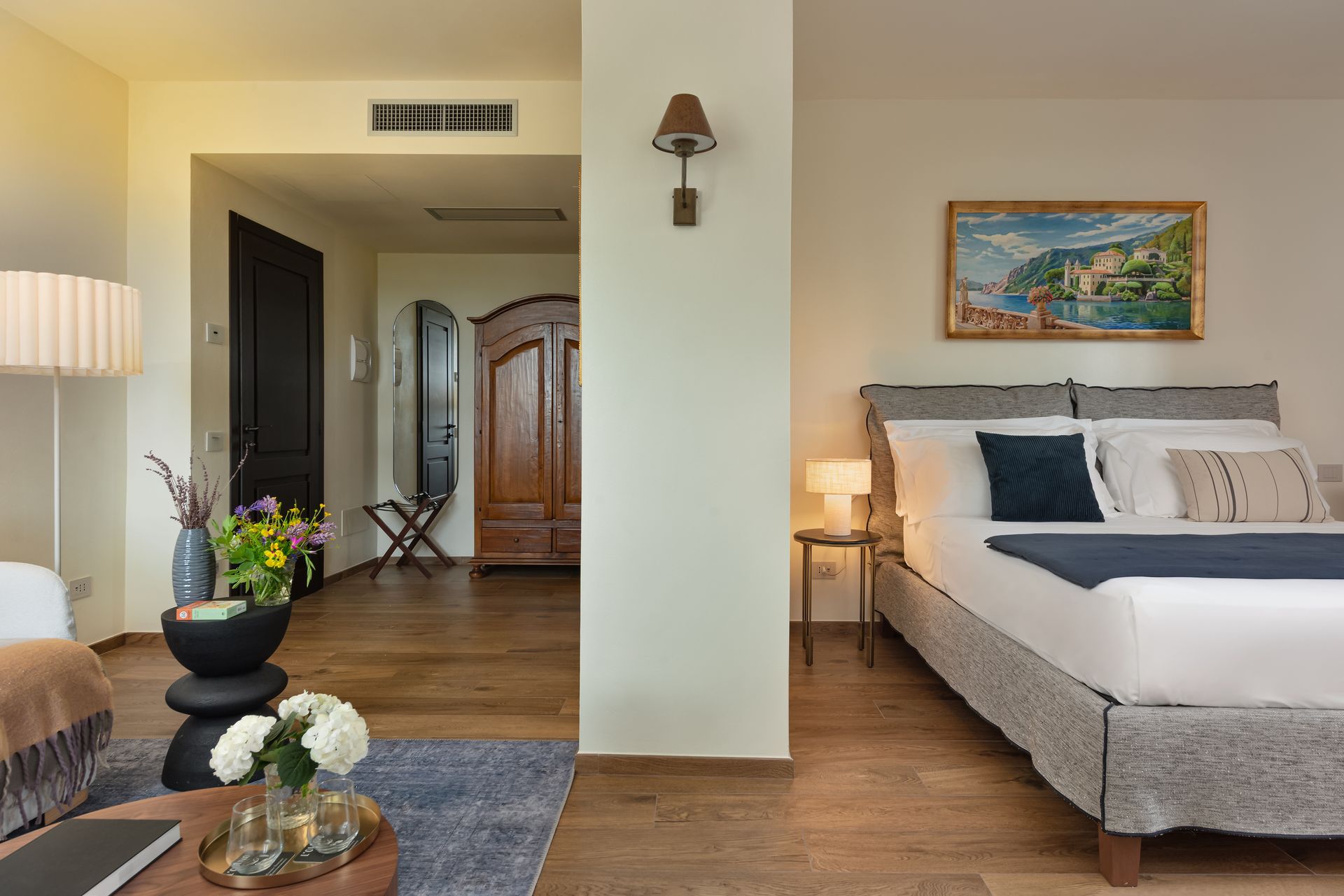 A hotel room with a king size bed and a living room in Italy.