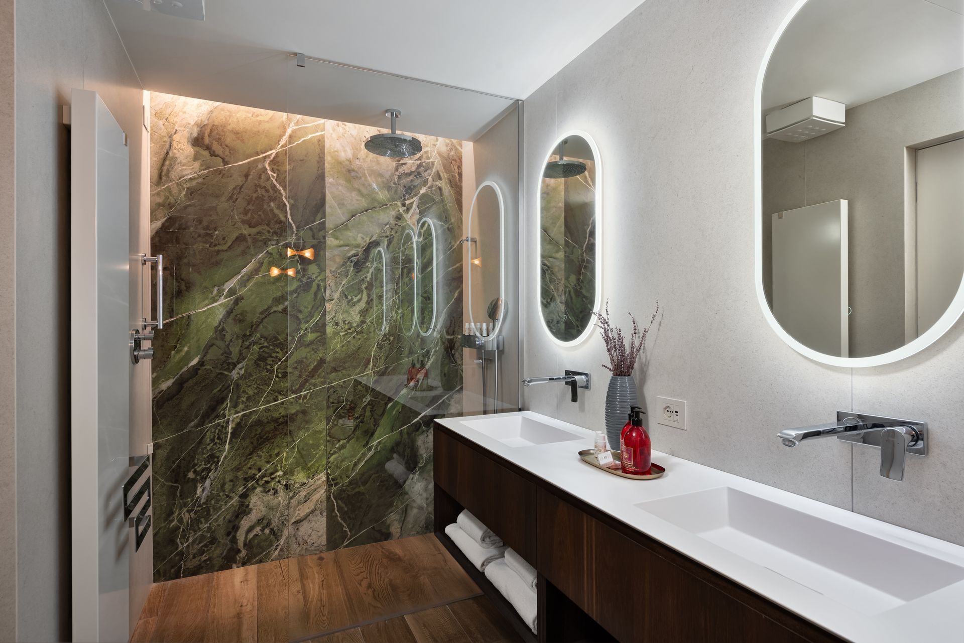 A bathroom with two sinks ,  luxury shower and a mirror in Italy.