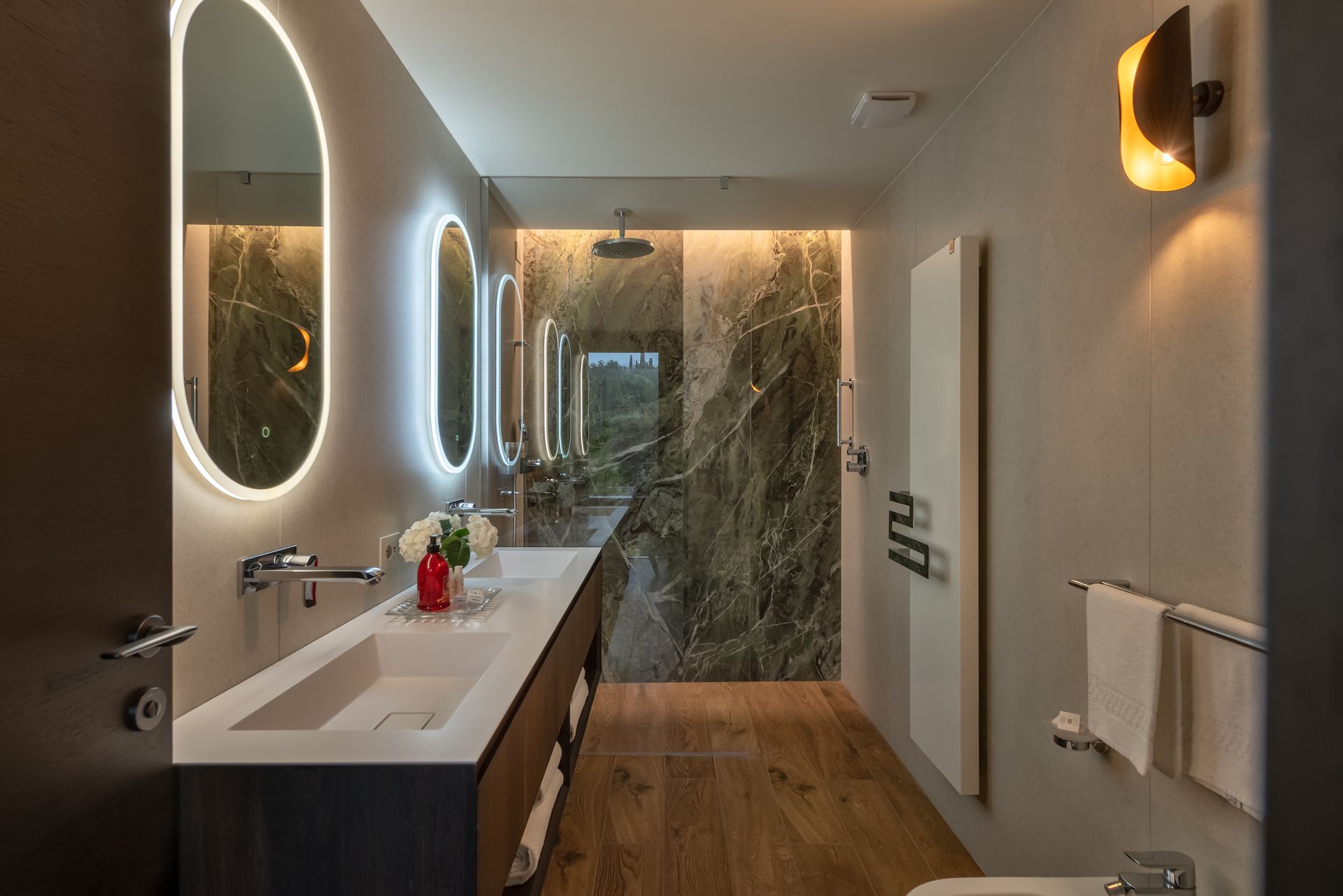 A private hotel bathroom with a sink , toilet and mirrors.