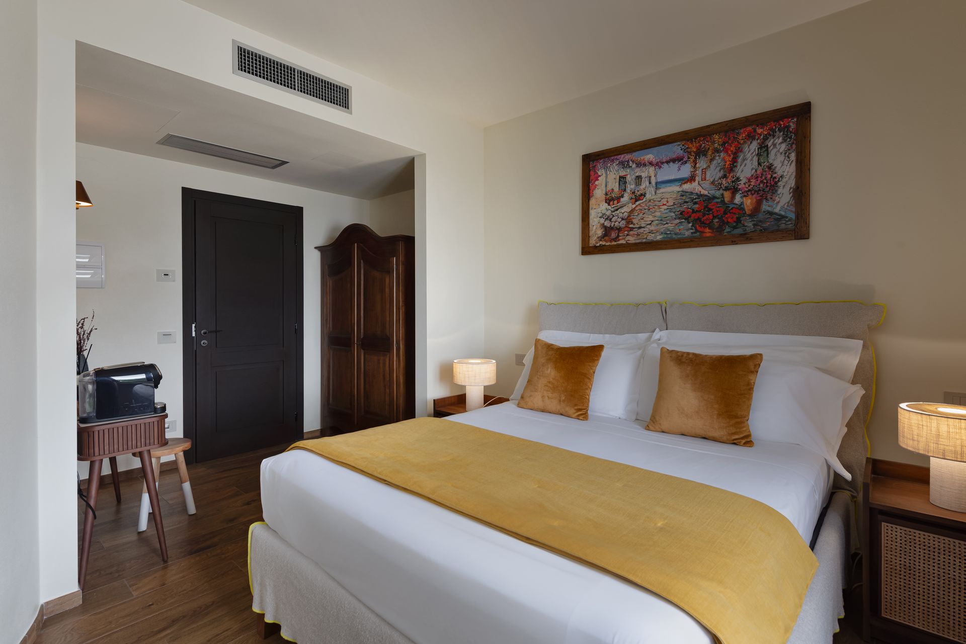A hotel room with a large bed and a painting on the wall near Pienza.