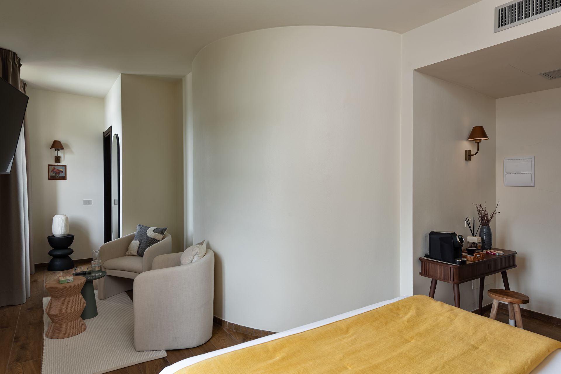 A unique hotel suite with a bed , chairs and a desk