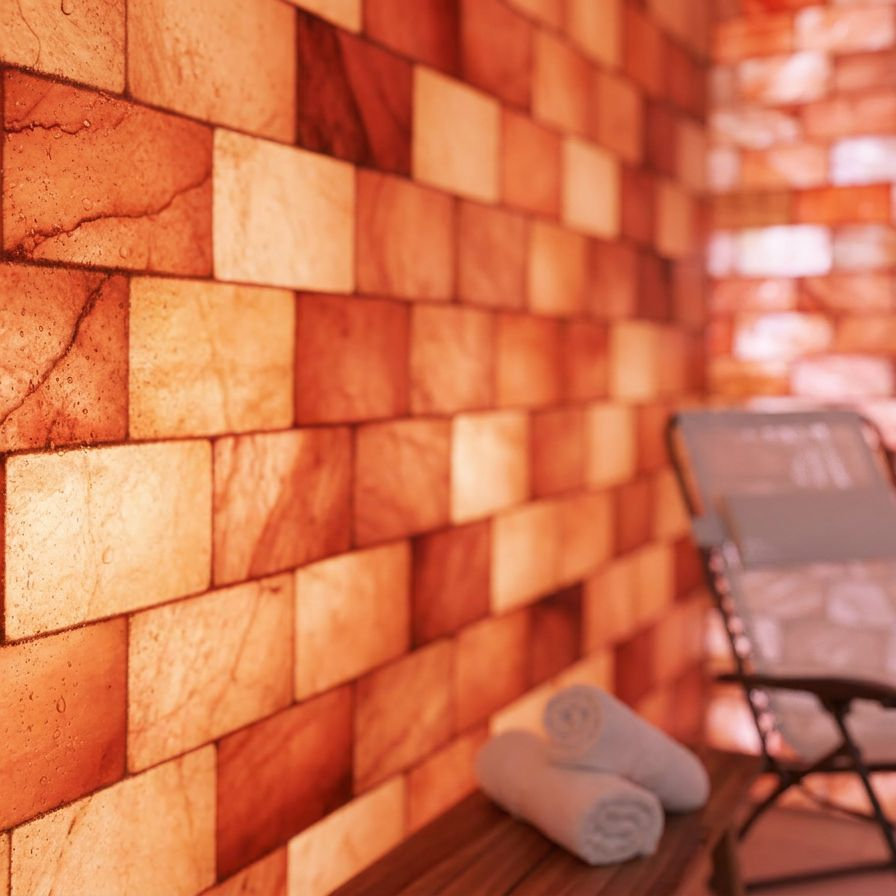 A wooden sauna with a lot of salt bricks on the wall