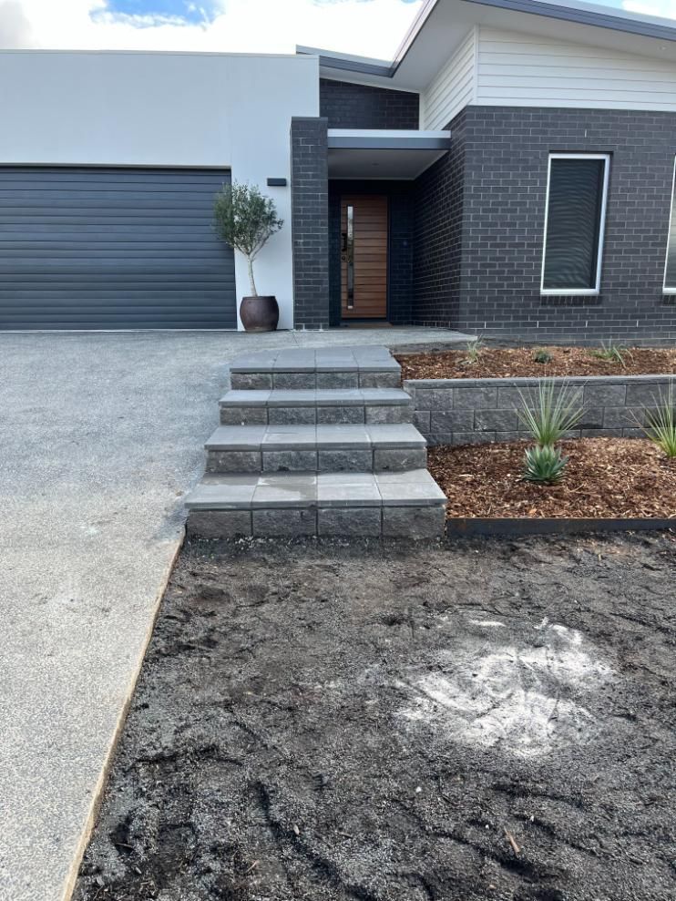 A House With Stairs Leading Up To The Front Door And A Garage — Lewis Landscapes In Port Macquarie, NSW