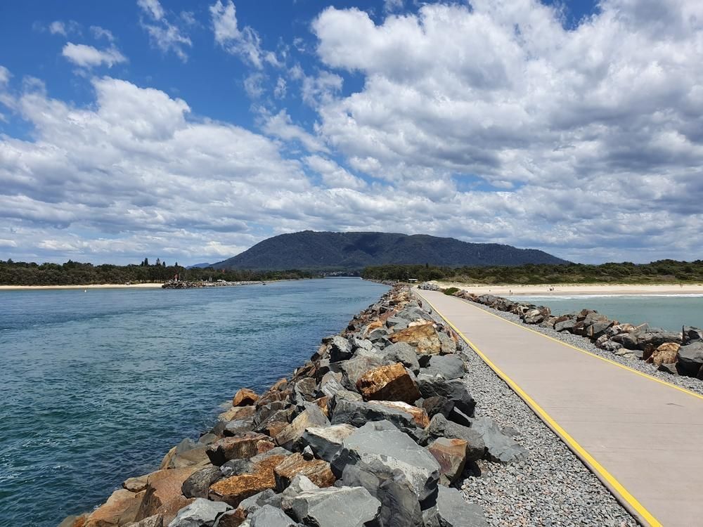 A Road Going Over A Body Of Water With A Mountain In The Background — Lewis Landscapes In Laurieton, NSW