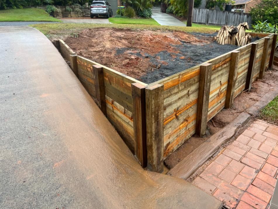 A Car Is Parked In A Driveway Next To A Wooden Fence — Lewis Landscapes In Port Macquarie, NSW