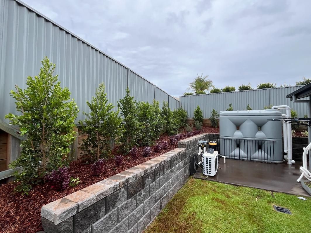 A Fence With A Water Tank In The Backyard Of A House — Lewis Landscapes In Yippin Creek, NSW