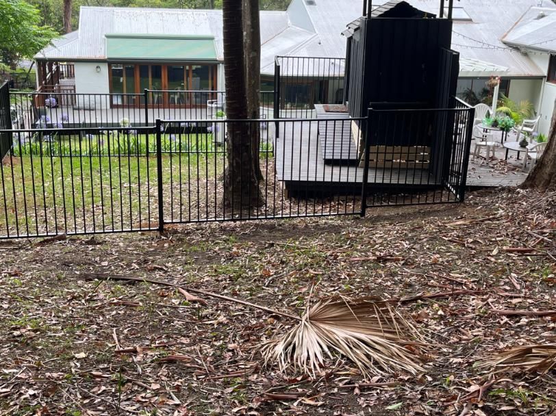 A Fence Surrounds A Yard With A House In The Background — Lewis Landscapes In Wauchope, NSW