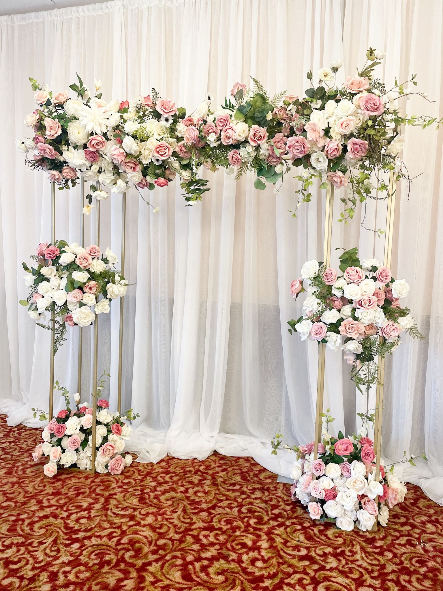 a room decorated with flowers and a white curtain and backdrop