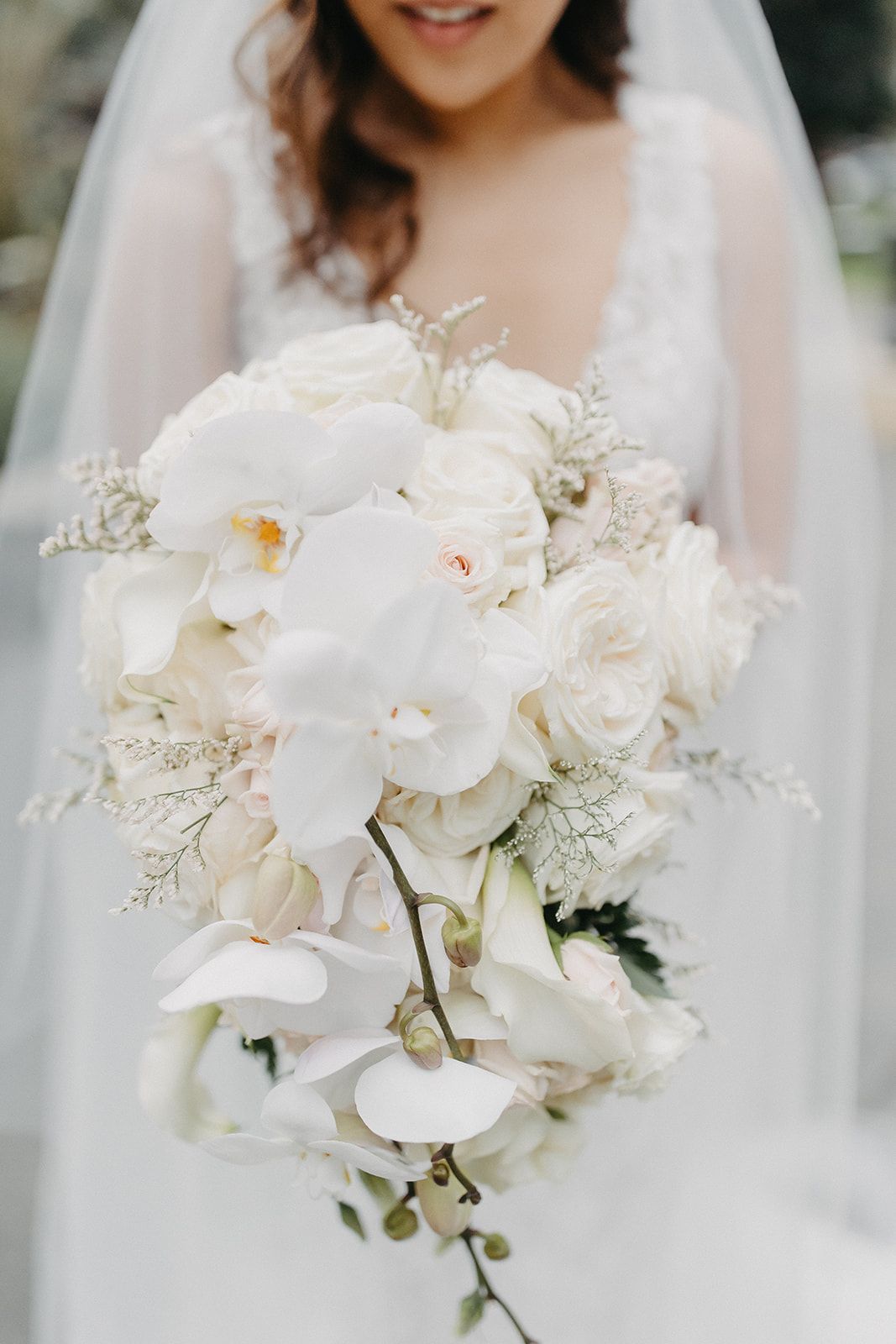 the bride is holding a bouquet of white flowers