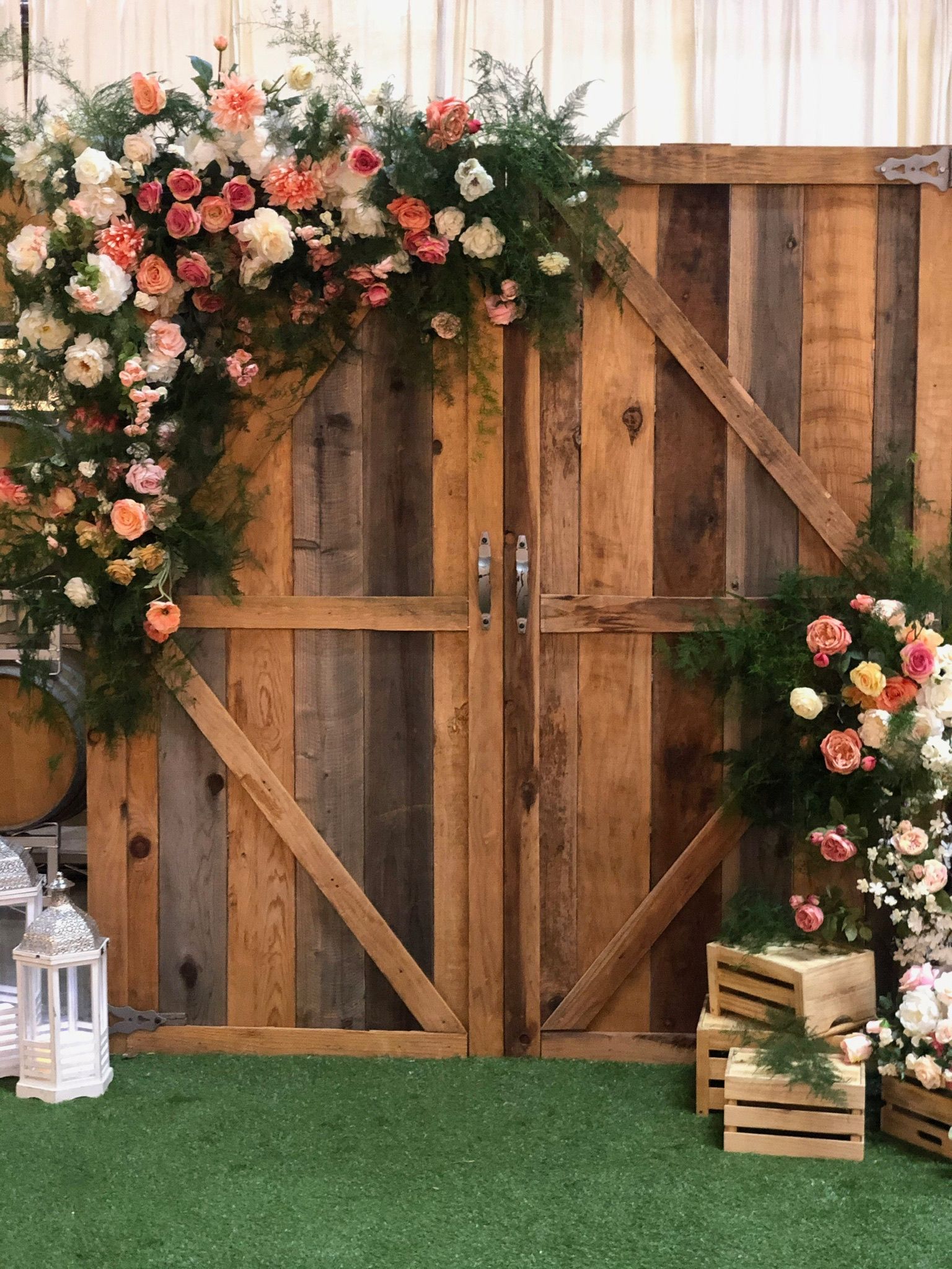 a wooden gate is decorated with flowers and crates