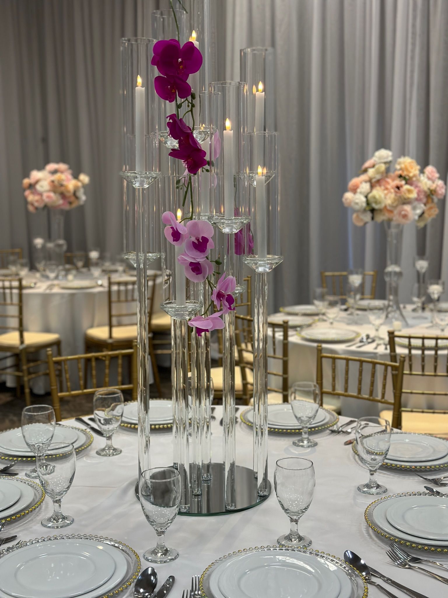 a table set for a wedding reception with purple flowers and candles