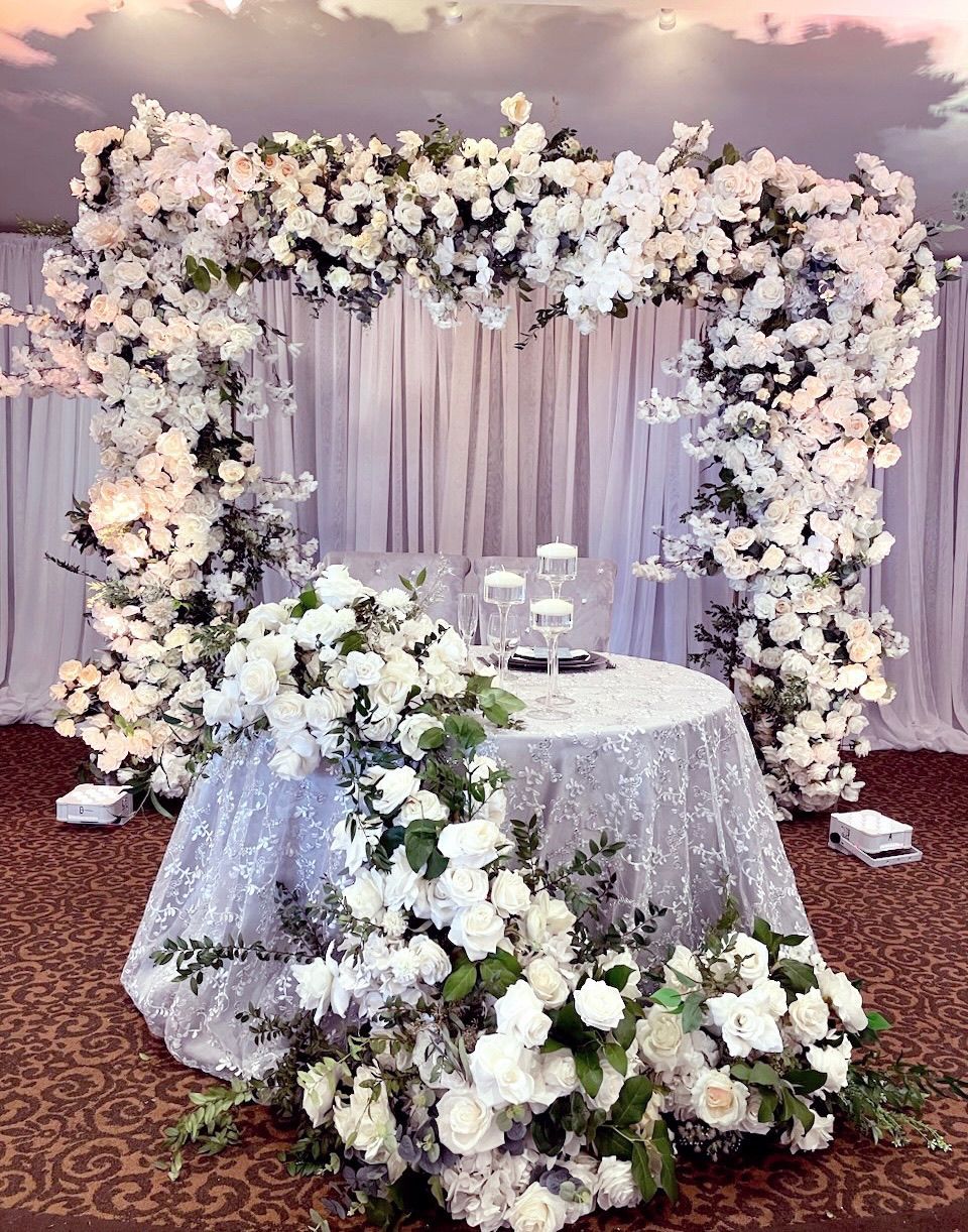 a table is decorated with white flowers and candles
