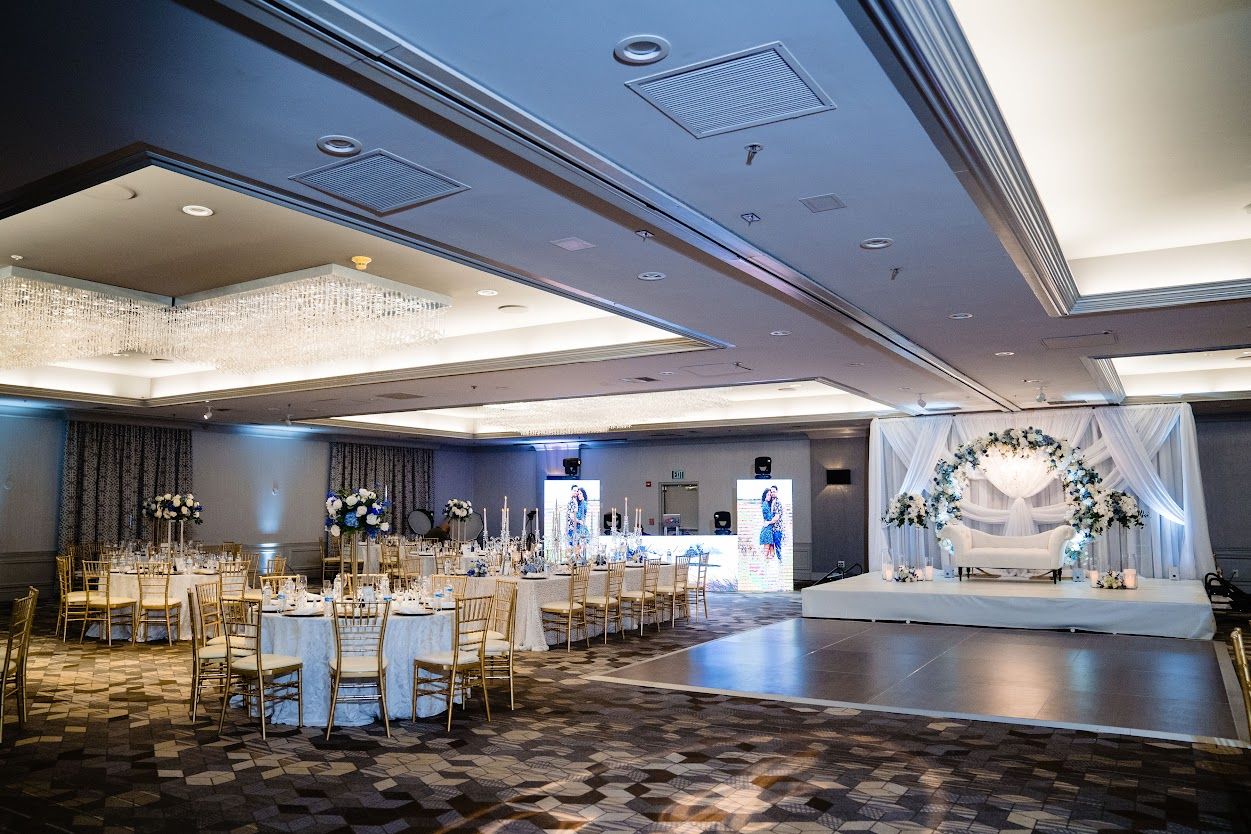 A large ballroom filled with tables and chairs and a dance floor.