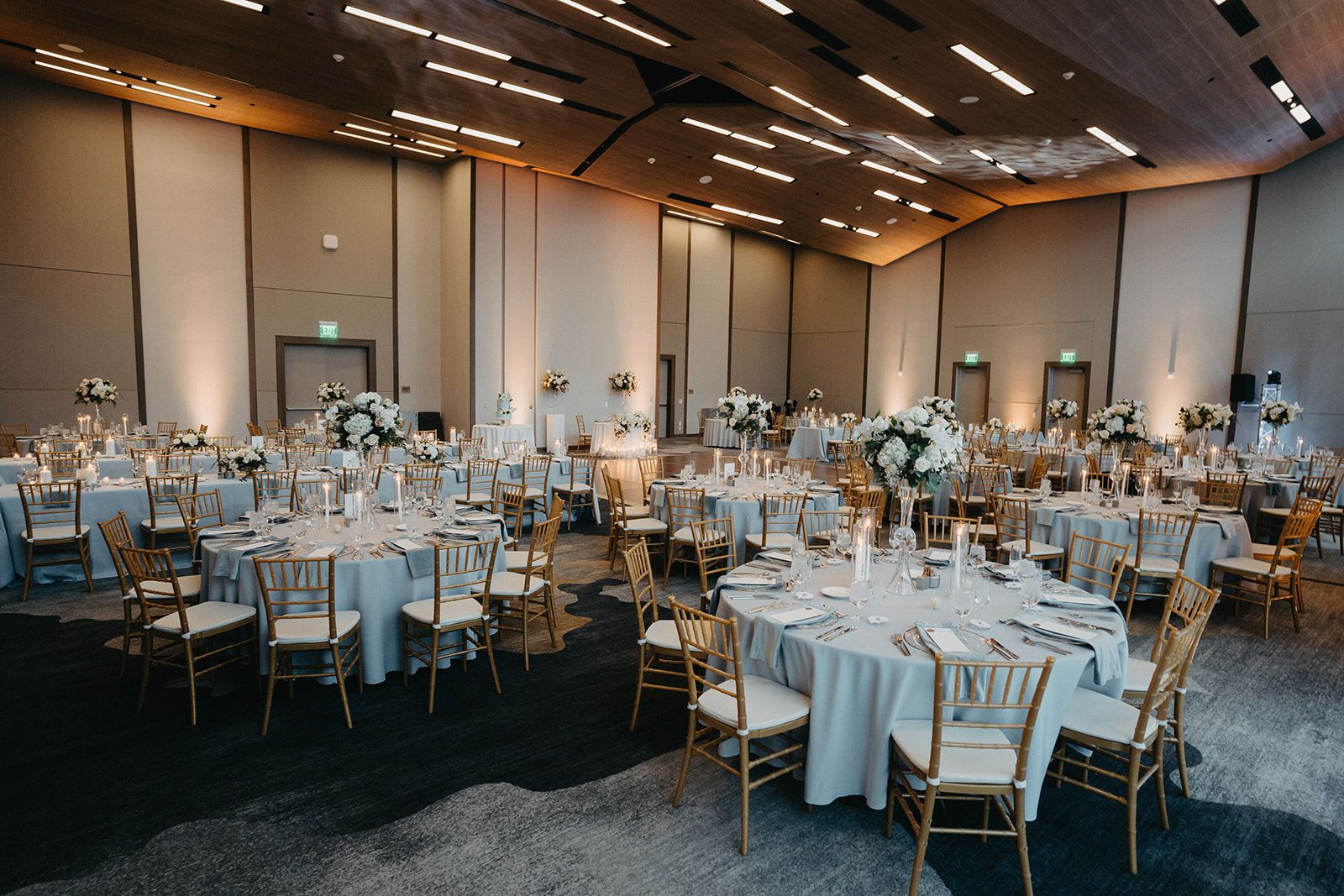 A large room with tables and chairs set up for a wedding reception.