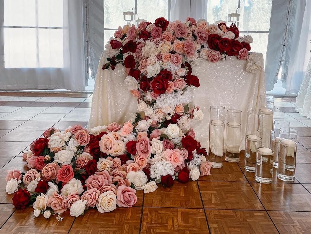 A table with flowers and candles on it in a room.