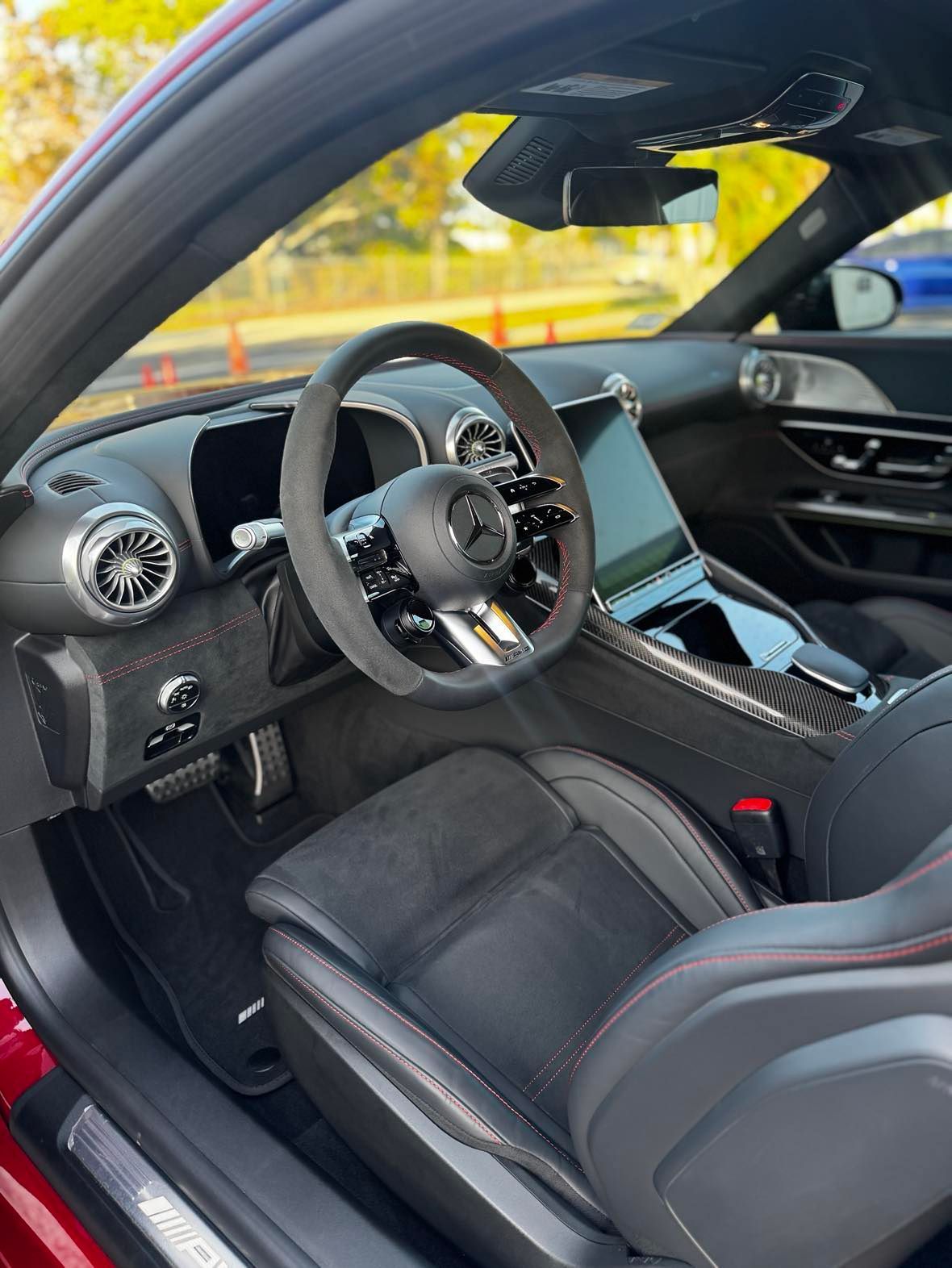 The interior of a red sports car with a steering wheel and seats.