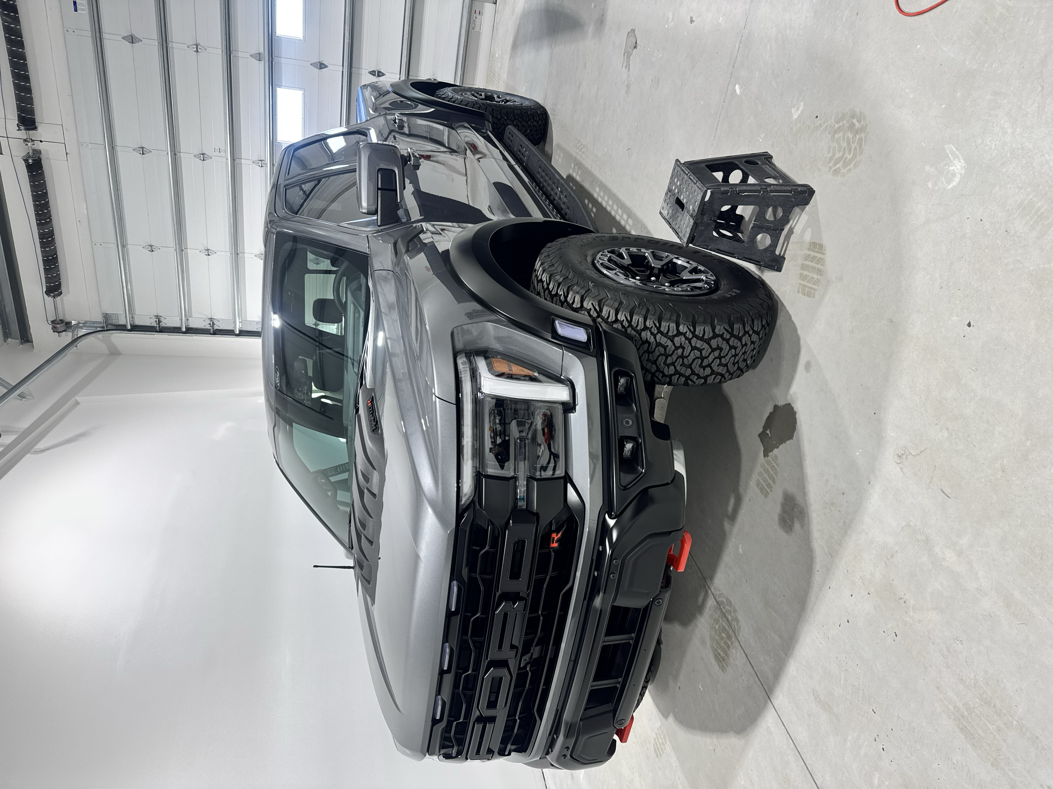 Gray Ford Raptor pickup truck parked in a garage.