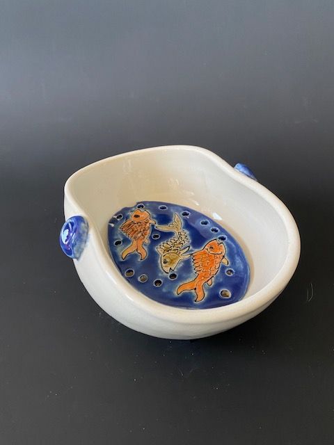 White ceramic bowl with blue interior; goldfish swimming.