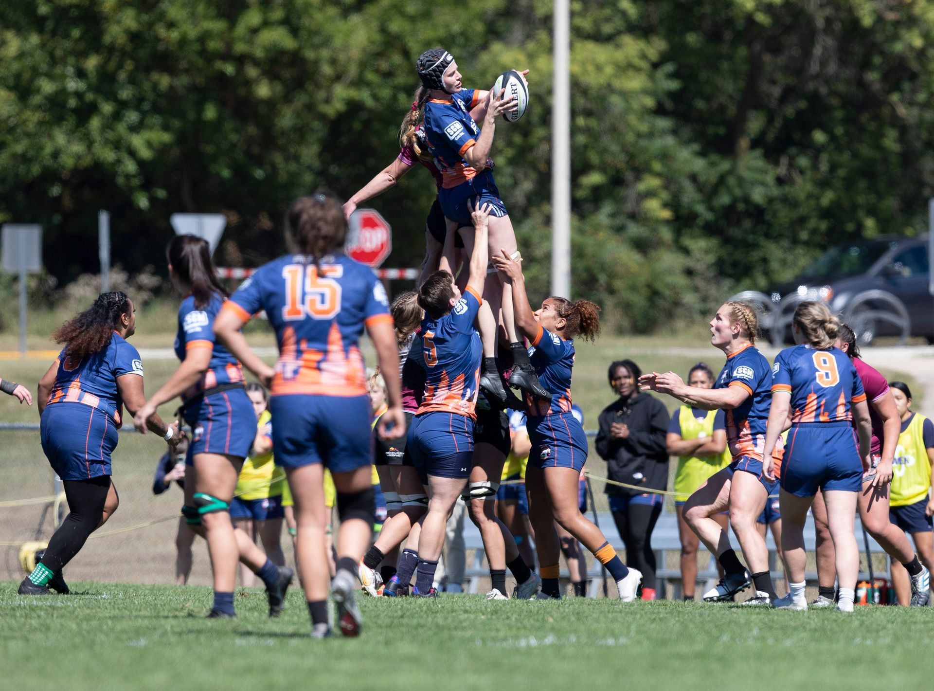 A group of women are playing rugby on a field.