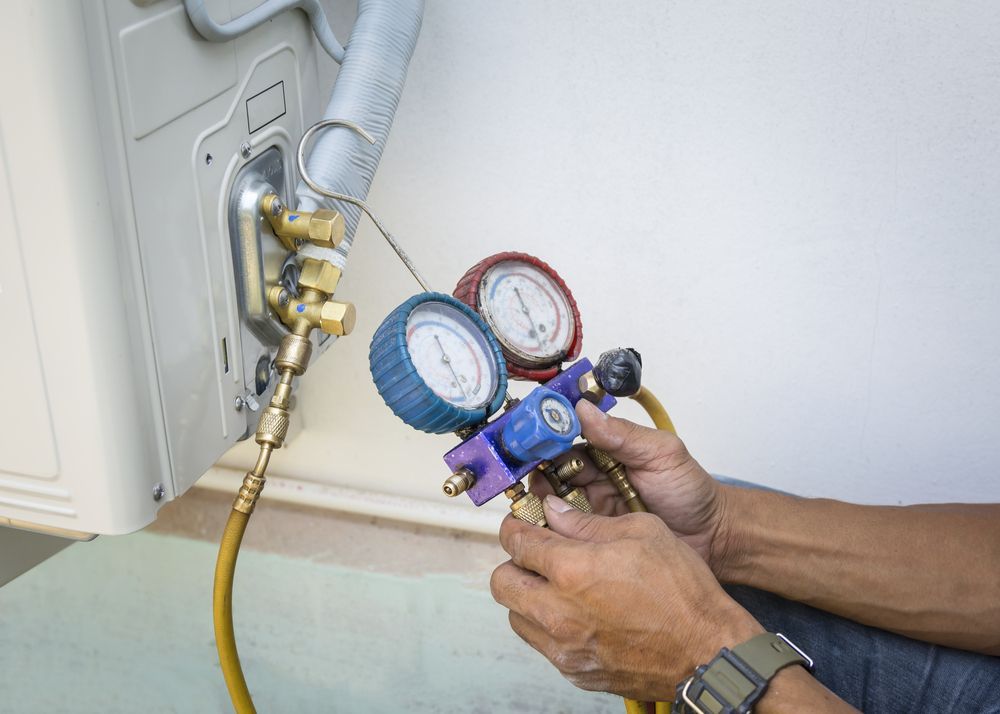 Technician is Checking Air Conditioner With Manometers, Measuring Equipment for Filling Air Conditioners — Replace Your Home’s Air Conditioner in Townsville, QLD