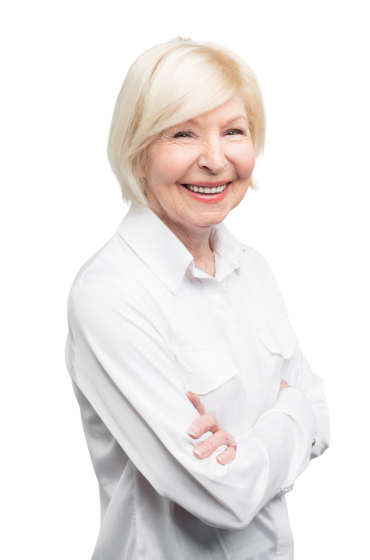 An older woman in a white shirt is smiling with her arms crossed.