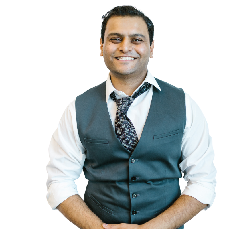 A man wearing a vest and tie smiles for the camera