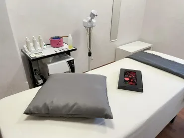 Sala per trattamenti spa con lettino per massaggi, attrezzatura e cuscino.