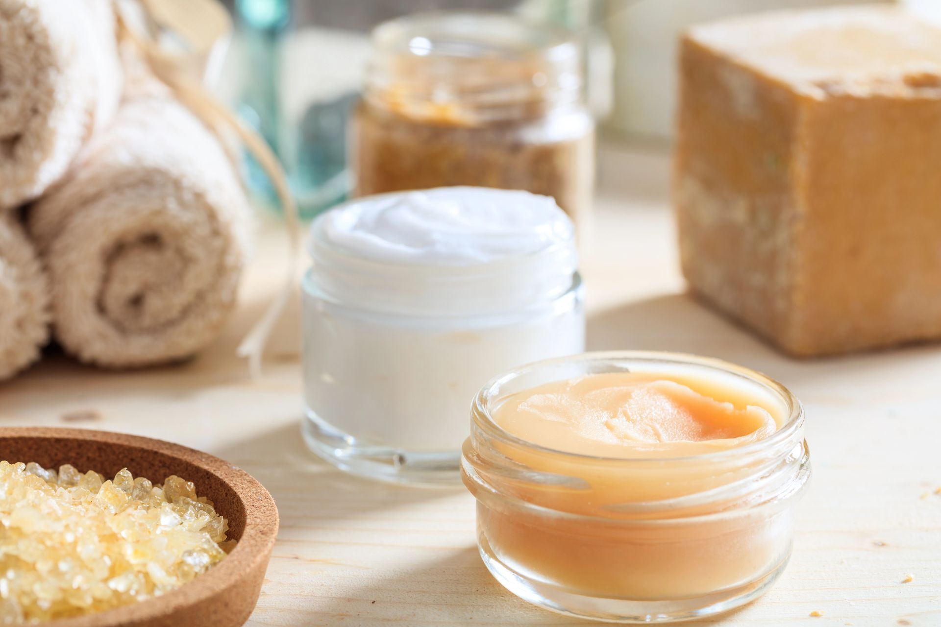 Prodotti per la spa, tra cui creme, sali e asciugamani, disposti su una superficie di legno.