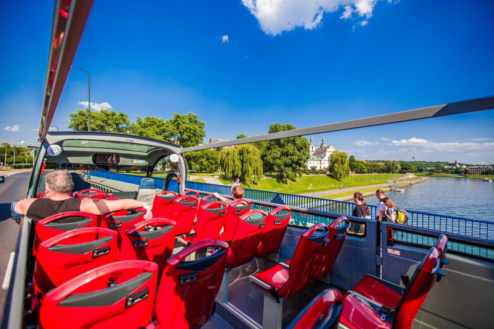 Krakow hop-on hop-off bus — tourists on the upper deck with views of the Old Town