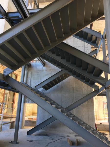 Steel stair structure with intersecting flights in an unfinished building interior