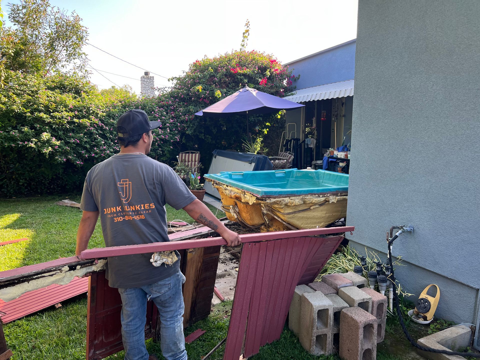 Person holding broken jacuzzi material during a jacuzzi removal.