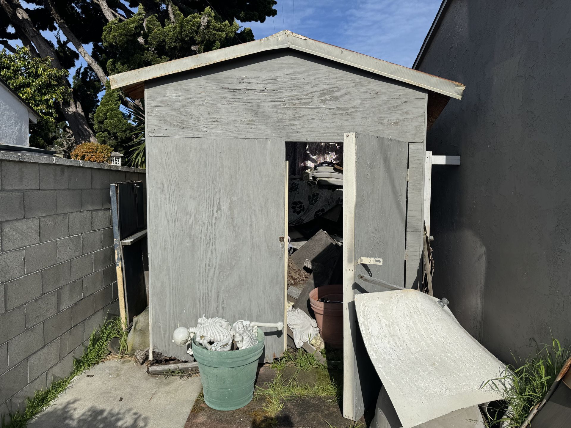 backyard shed being demolished, junk being removed