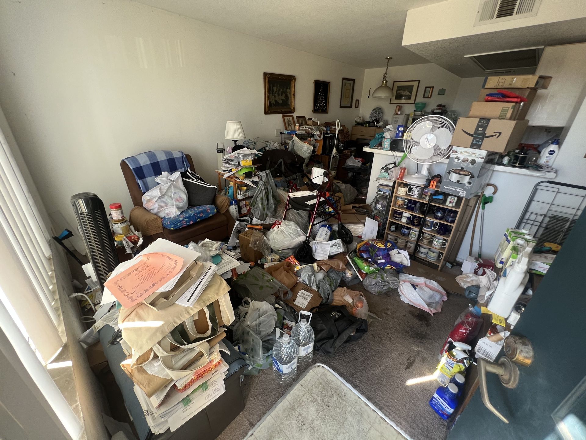 Cluttered living room and kitchen area before a hoarder cleanout in Torrance