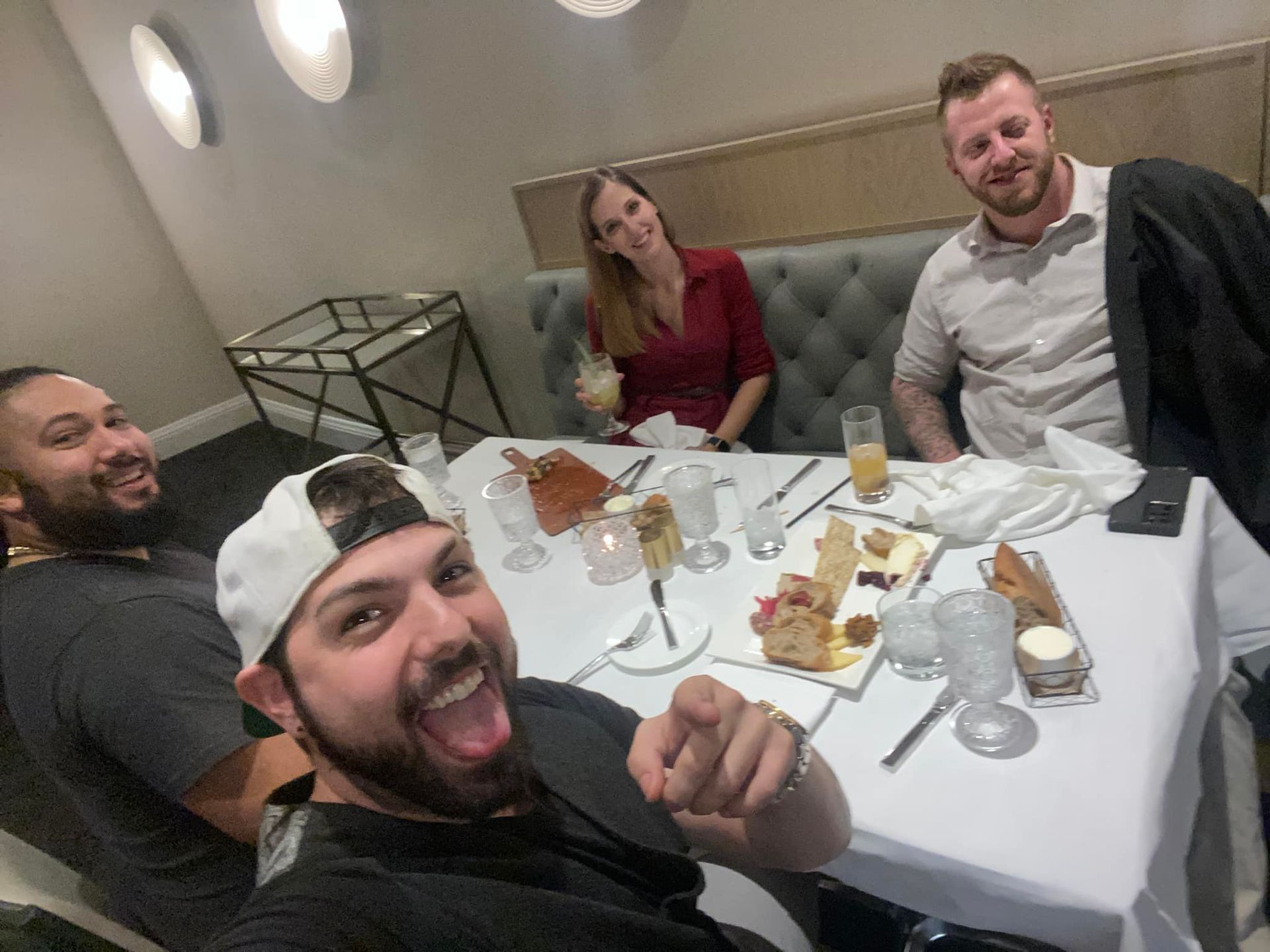 A group of people are sitting at a table with food and drinks.