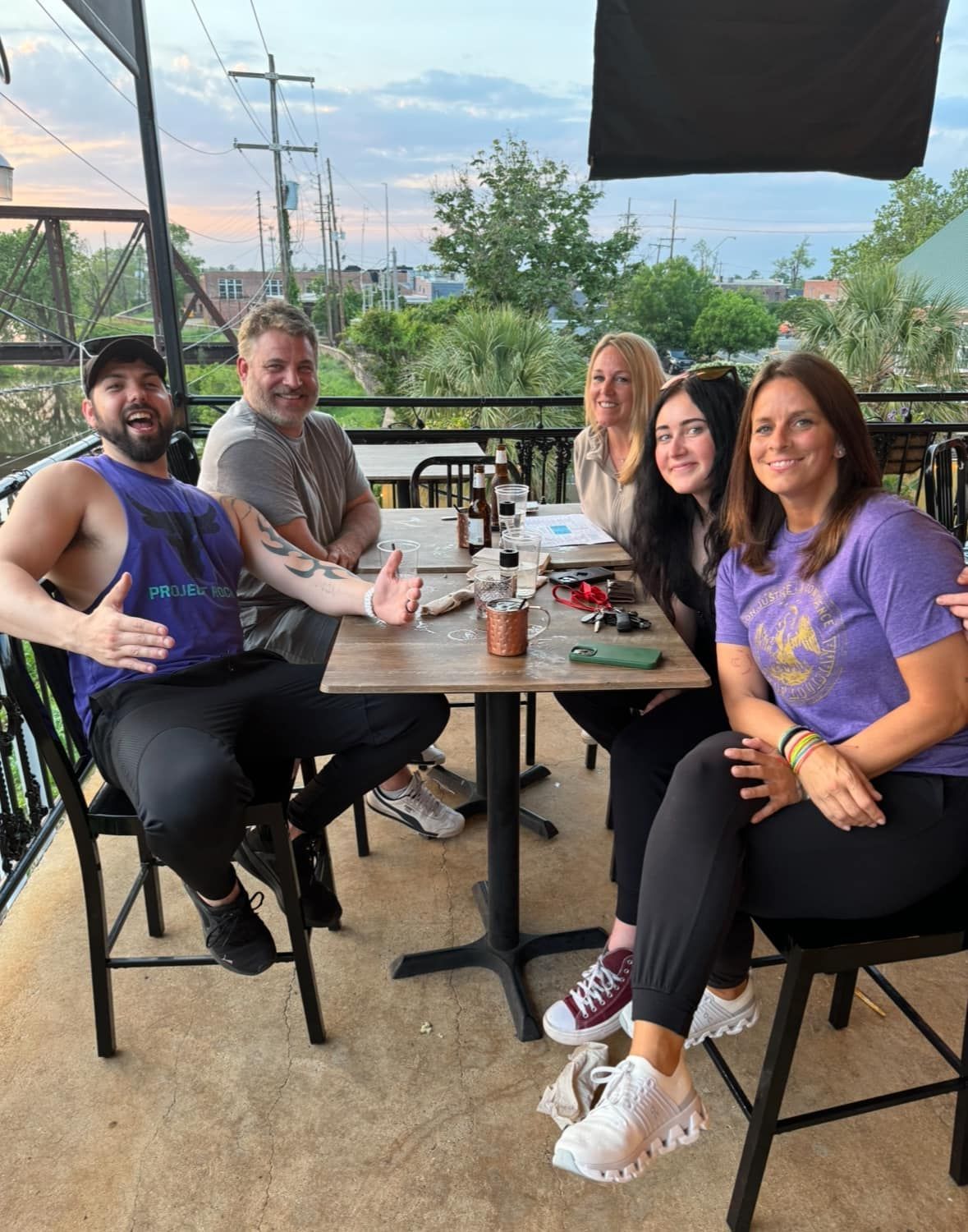 A group of people are sitting at a table on a balcony.