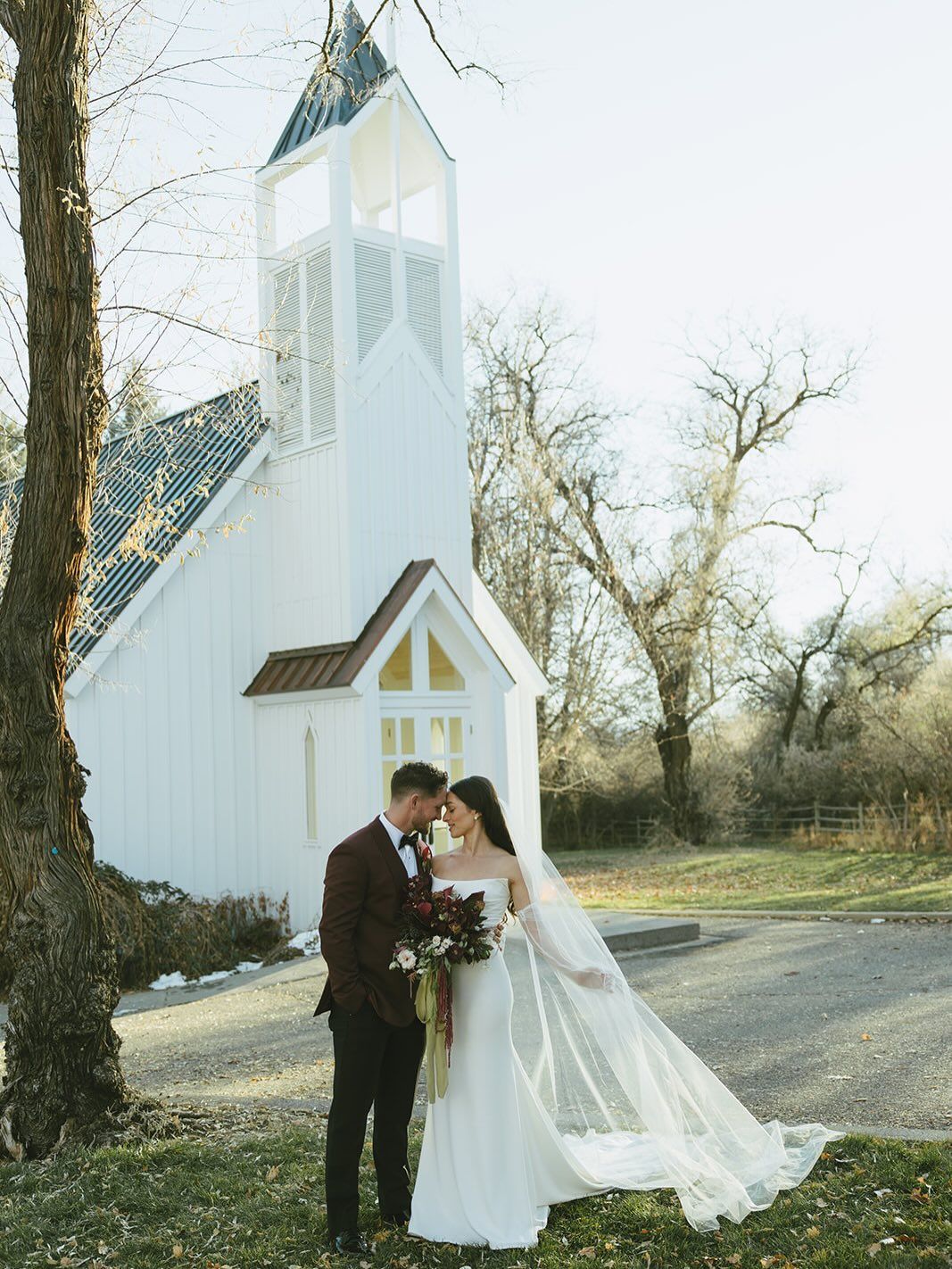 A bride in a white dress is holding a bouquet of flowers.