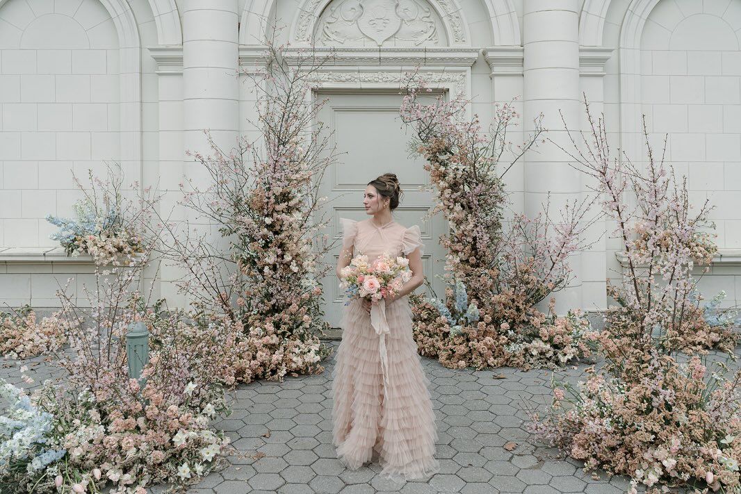 A woman in a white dress is holding a bouquet of flowers.