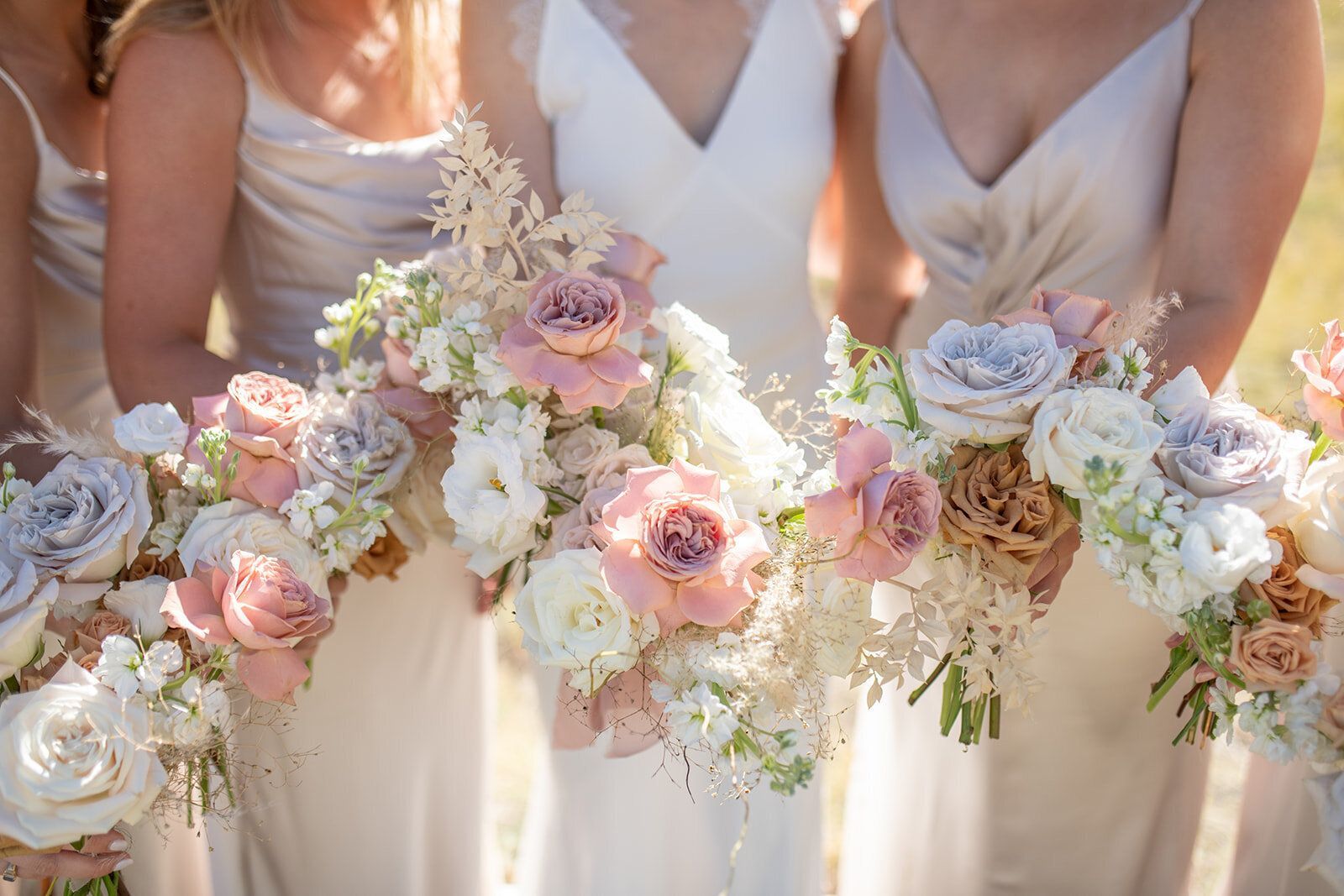 A bride and her bridesmaids are holding bouquets of flowers.