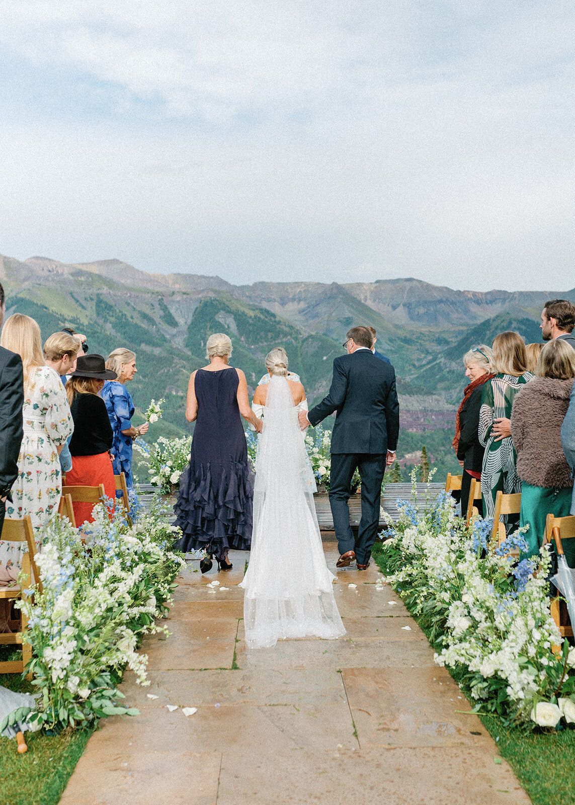A bride and groom are walking down the aisle at their wedding.