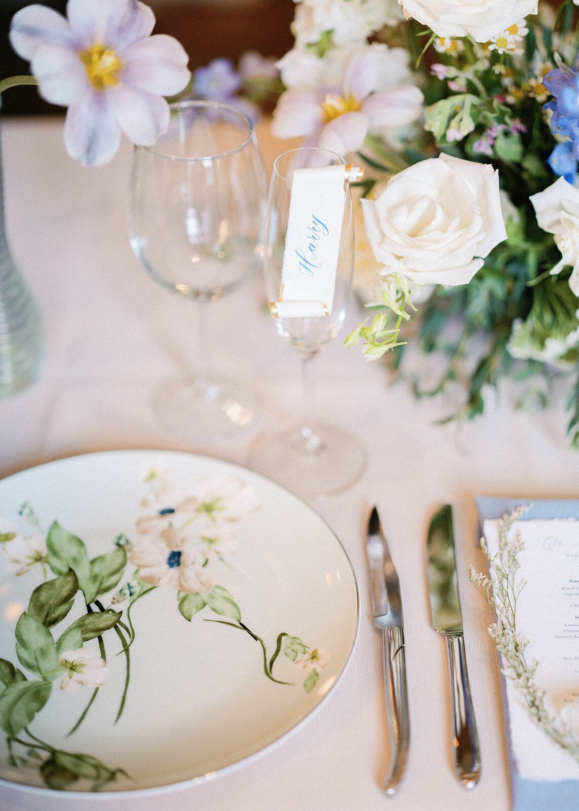 A plate with flowers on it is sitting on a table next to a vase of flowers.