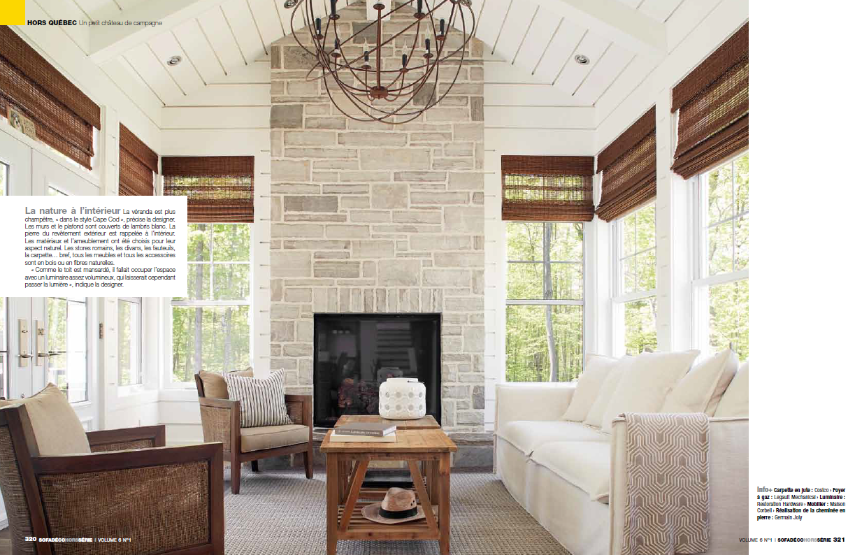A living room with a fireplace , couch , chairs and a chandelier.